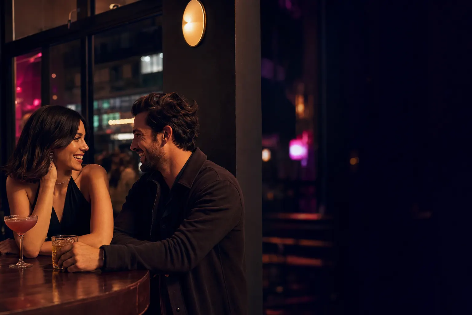 Two adults smiling together on a date at a city bar